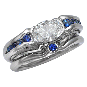 Carved Curls Engagement Ring with Oval Diamond and Tapering Blue Sapphires