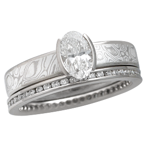 Mokume Solitaire Straight Tapered Engagement Ring with an Oval Diamond and Diamond Channel Brilliant Eternity Band