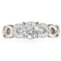 This engagement ring features infinity symbols around the band.  The infinity beneath the head has diamond pave and millegrain detail. 