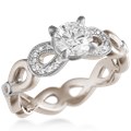 This engagement ring features infinity symbols around the band.  The infinity beneath the head has diamond pave and millegrain detail. 