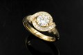 This ring was inspired by early 20th century jewelry design, but is simultaneously contemporary.  A "ribbon" of millegraining and bead-set accent stones gracefully wrap around and underneath the center stone.