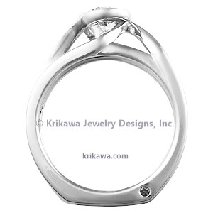 This contemporary engagement, designed to wrap around the wedding band, is comprised of mostly negative space. 