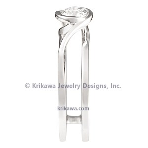 This contemporary engagement, designed to wrap around the wedding band, is comprised of mostly negative space. 