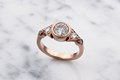 Art Deco lines and vintage details effortlessly blend together in this three stone engagement ring.