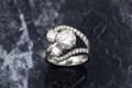 As the sun glimmers and reflects off the cascading waves, the pave set diamonds flow across the band and shimmer like ribbons around the three distinct stones.