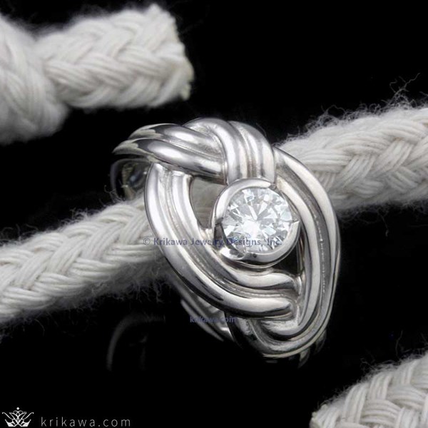 An endless knot wraps the center stone of your choice! The knot is a beautiful symbol of your eternal love and becomes the support of the semi-bezel solitaire in this organic ring design.