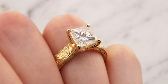 Hand Engraved Marigold Engagement Ring on Finger
