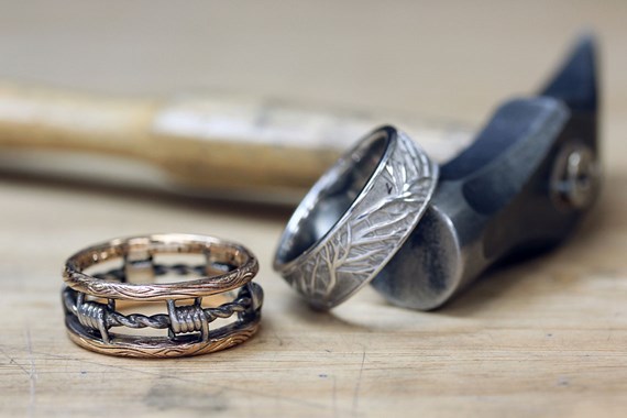 two mens wedding bands with a hammer